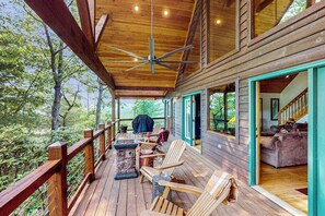 A wooden deck with outdoor seating, a ceiling fan, and a view of the surrounding forest. - Wildcat Retreat (Murphy)