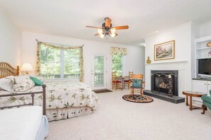 A bedroom with a bed, a desk, a chair, a fireplace, and a television. - Two-part villa near the slopes with hot tub, pools, golf on-site, & fast WiFi (Sapphire)