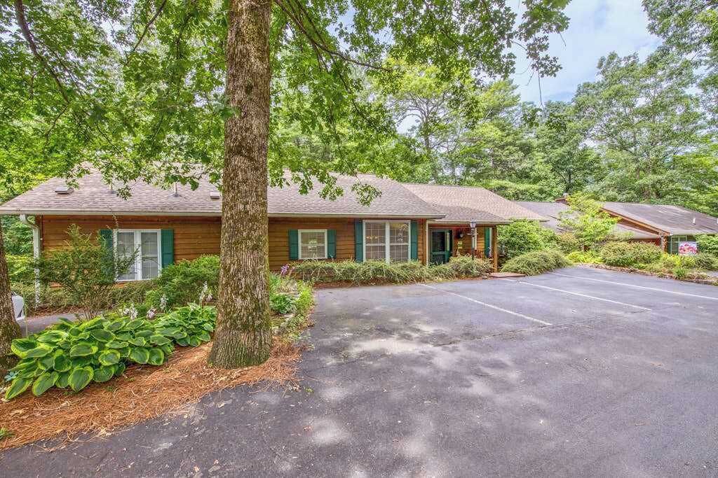 A row of cabins with a paved driveway and surrounding greenery.
