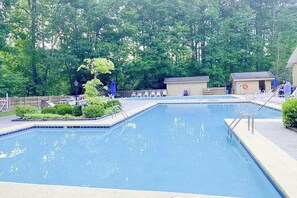A rectangular swimming pool with a tiled edge, surrounded by a low brick wall and a wooden fence. - Two-part villa near the slopes with hot tub, pools, golf on-site, & fast WiFi (Sapphire)