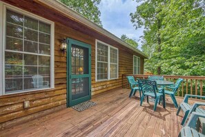 A wooden cabin with a deck, a door, and a table with chairs. - Two-part villa near the slopes with hot tub, pools, golf on-site, & fast WiFi (Sapphire)