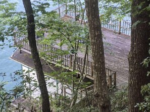 A wooden deck with railings overlooking a body of water.