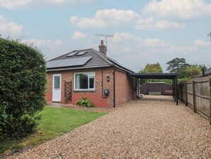 A house with a gravel driveway, a covered carport, and a brick chimney. - 2 North Road (Dorchester)