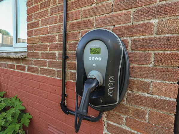 Eine Ladestation für Elektroautos an einer Ziegelwand.