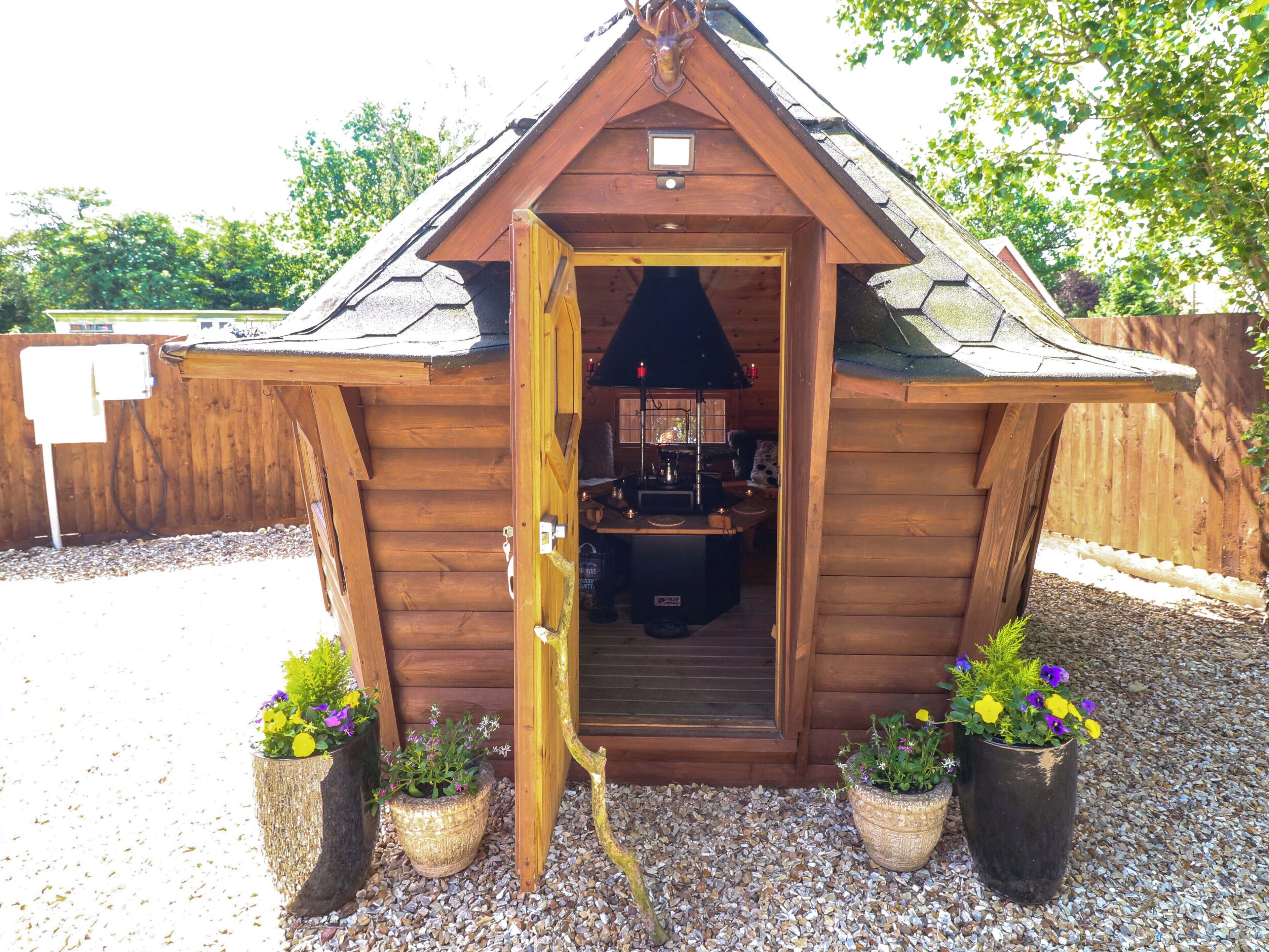 Una estructura de madera con una puerta, un ventanal pequeño y una chimenea.