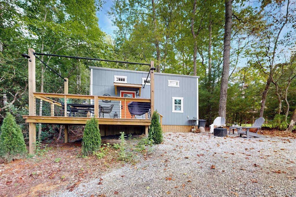 Une cabane avec une terrasse, un petit porche et un sol en gravier.