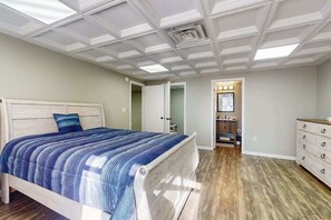 Ein Schlafzimmer mit Bett, Schminktisch, Kommode und einer Decke mit Dachfenstern.