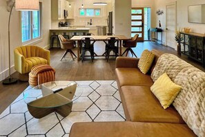 Ein modernes Wohnzimmer mit Sofa, Sessel und Couchtisch.