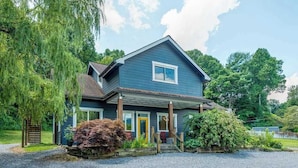 A two-story house with a blue exterior, a front porch, and a gravel driveway. - Idyllic home with 2 separate apartments near skiing/hiking - firepit, fast WiFi (Swannanoa)