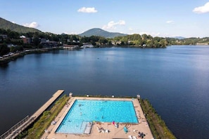 Une piscine avec vue sur un lac et des montagnes en arrière-plan.