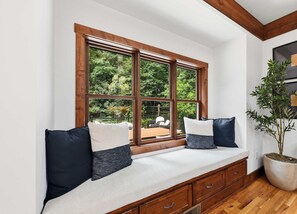 A room with a built-in bench along a large window overlooking a garden. - Charming house in Brevard with heated outdoor pool, tennis court, and a gym (Brevard)