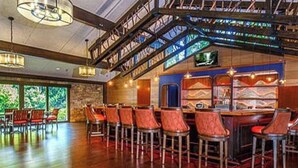 A bar area with wooden flooring, red bar stools, and a staircase with metal railings. - Charming house in Brevard with heated outdoor pool, tennis court, and a gym (Brevard)