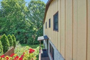 Ein zweistöckiges Haus mit überdachter Veranda und einem gepflegten Garten.