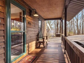 A wooden cabin with a porch, a bench, and a door leading to the interior. - Family Escape at Rumbling Bald with Firepit, Games & Fiber Internet (Lake Lure)