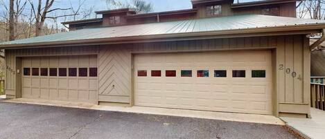 A two-story building with a garage, a chevron-patterned door, and a number '202' on the garage door.
