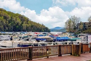 Un port de plaisance avec des bateaux amarrés, une clôture en bois et un paysage vallonné en arrière-plan.