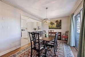 Ein Esszimmer mit großem Tisch, Stühlen und einer Chandelüster.