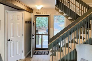 A staircase with a handrail, a door with a sign, and a view of the outdoors. - Lake-view dog-friendly condo with pools, hot tub, sauna, tennis, & balcony (Sapphire)