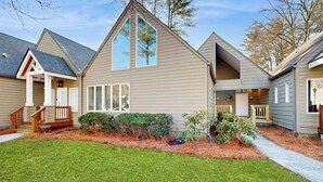 A two-story house with a front porch, a covered entryway, and a landscaped yard.