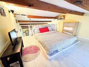 A bedroom with a bed, a desk with a computer, a dresser, and a wooden ceiling. - Ostrica Apartment (Lumio)