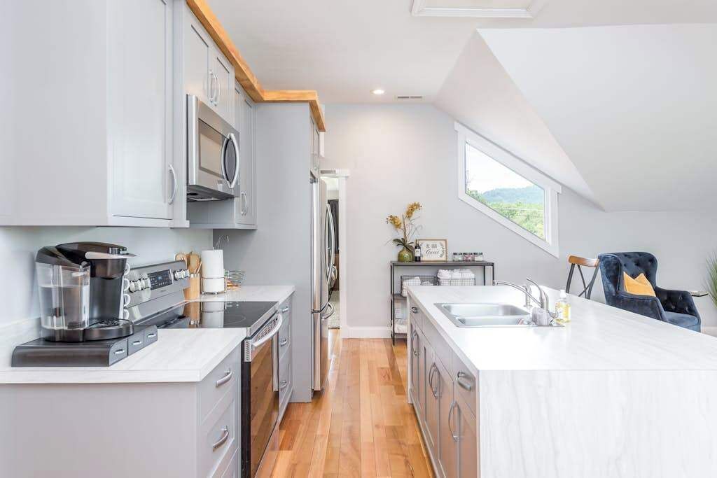 A modern kitchen with a central island, built-in appliances, and a view of the outdoors.