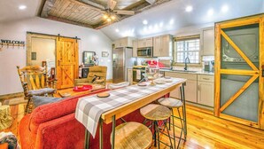 A kitchen with wooden beams, a bar area, and a large sliding door. - Stylish dog-friendly cottage with modern feel, fast WiFi, ideal location & more (Swannanoa)