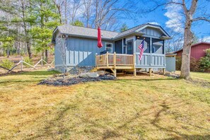 A small cabin with a deck, an American flag, and a mailbox. - Stylish dog-friendly cottage with modern feel, fast WiFi, ideal location & more (Swannanoa)
