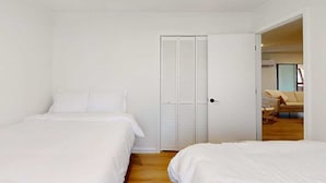 A bedroom with two beds, a white wardrobe, and a door leading to another room. - Once Upon a Cabin, Mountain Views (Murphy)