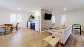 A modern apartment with a dining area, kitchen, living room, and a flat-screen TV mounted on the wall. - Once Upon a Cabin, Mountain Views (Murphy)