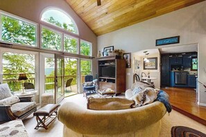 Un salón amplio con ventanas grandes, una zona de estar acogedora y vistas al exterior.