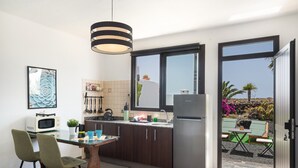 Una cocina moderna con comedor, refrigerador y vista a un jardín.