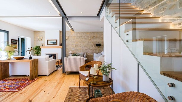 A modern interior with a wooden floor, a fireplace, a dining area, and a staircase. - Elegant Garden Villa Cascais by Portugal Portfolio (Cascais)