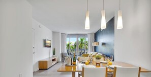Ein moderner Essbereich mit Holztisch, weißen Stühlen und Pendelleuchten.