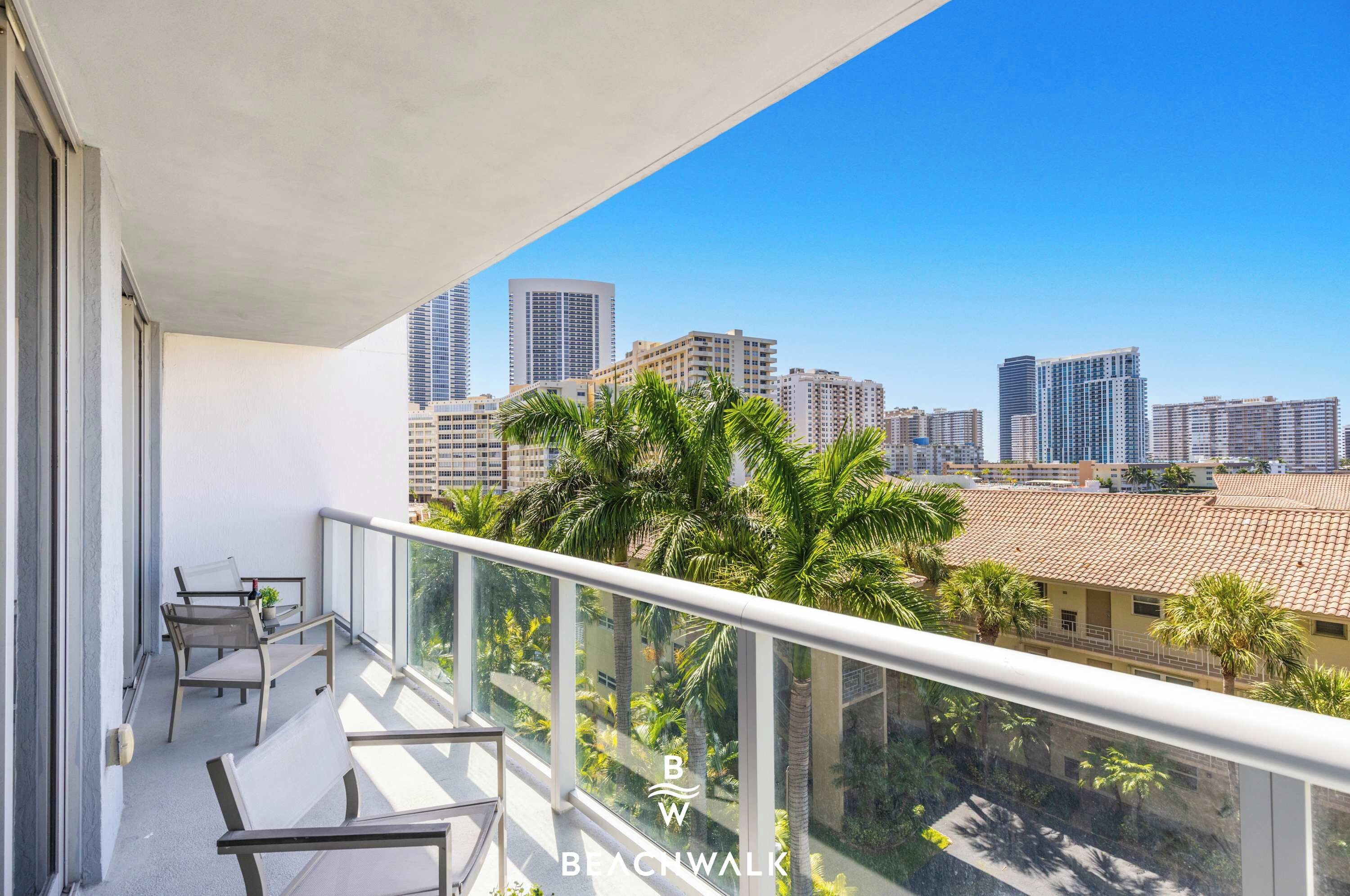 Un balcon avec vue sur la ville, une table et des chaises.