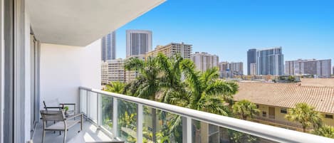 Un balcon avec vue sur la ville, une table et des chaises.