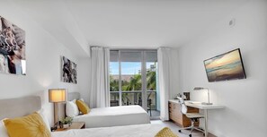 Habitación de hotel con cama, escritorio, silla, lámpara y obras de arte.
