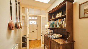 Un couloir avec une armoire en bois, une porte et un radiateur.
