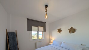 Ein Schlafzimmer mit Bett, Fenster mit Blick, Lampe und Handtuchhalter.