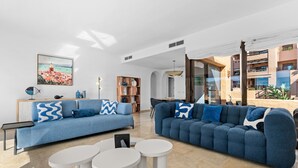 Un salon moderne avec deux canapés, une table basse et une bibliothèque.