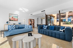 A modern living room with two sofas, a coffee table, and a bookshelf. - Coto Real Penthouse 2470 Naxos Sea View (Manilva)