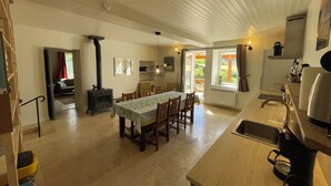 A spacious kitchen with a dining area, a built-in stove, and a large window providing natural light.