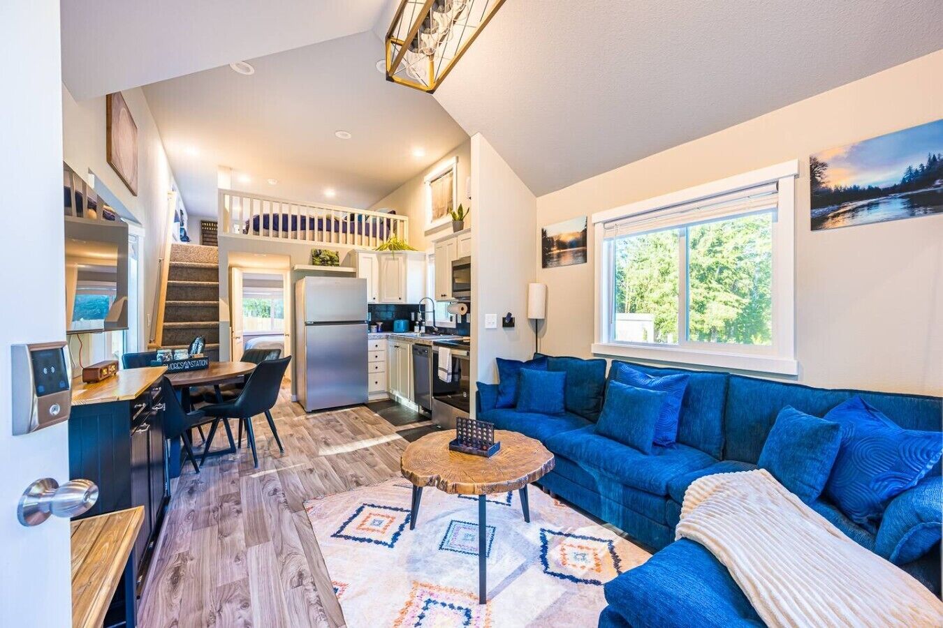 Un espacio habitable compacto con kitchenette, comedor y sofá.