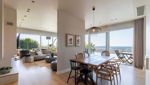 A spacious living area with a dining table, chairs, and a sofa.