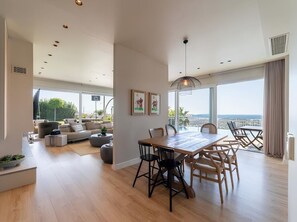 A spacious living area with a dining table, chairs, and a sofa.