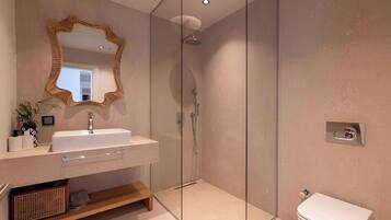 Un baño moderno con cabina de ducha de vidrio, un lavabo blanco con espejo y un inodoro.