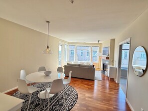 Un espacio habitable moderno con comedor, sofá y chimenea.