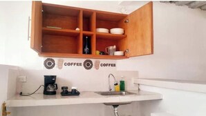 A kitchen with a wooden cabinet, a coffee machine, and a sink. - Apartment a few steps from the main square  (Villa de Leyva)