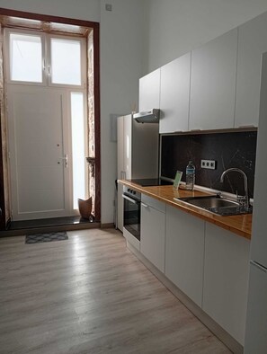 A modern kitchen with a wooden countertop, stainless steel sink, and a built-in oven. - Casa San Gregorio in the historic center of Telde, Las Palmas, Gran Canaria. (Telde)