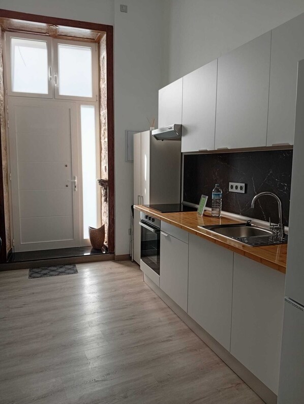 A modern kitchen with a wooden countertop, stainless steel sink, and a built-in oven. - Casa San Gregorio in the historic center of Telde, Las Palmas, Gran Canaria. (Telde)