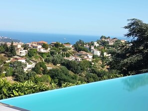 Ein Wohngebiet mit Häusern, einem Schwimmbad und Blick auf das Meer.